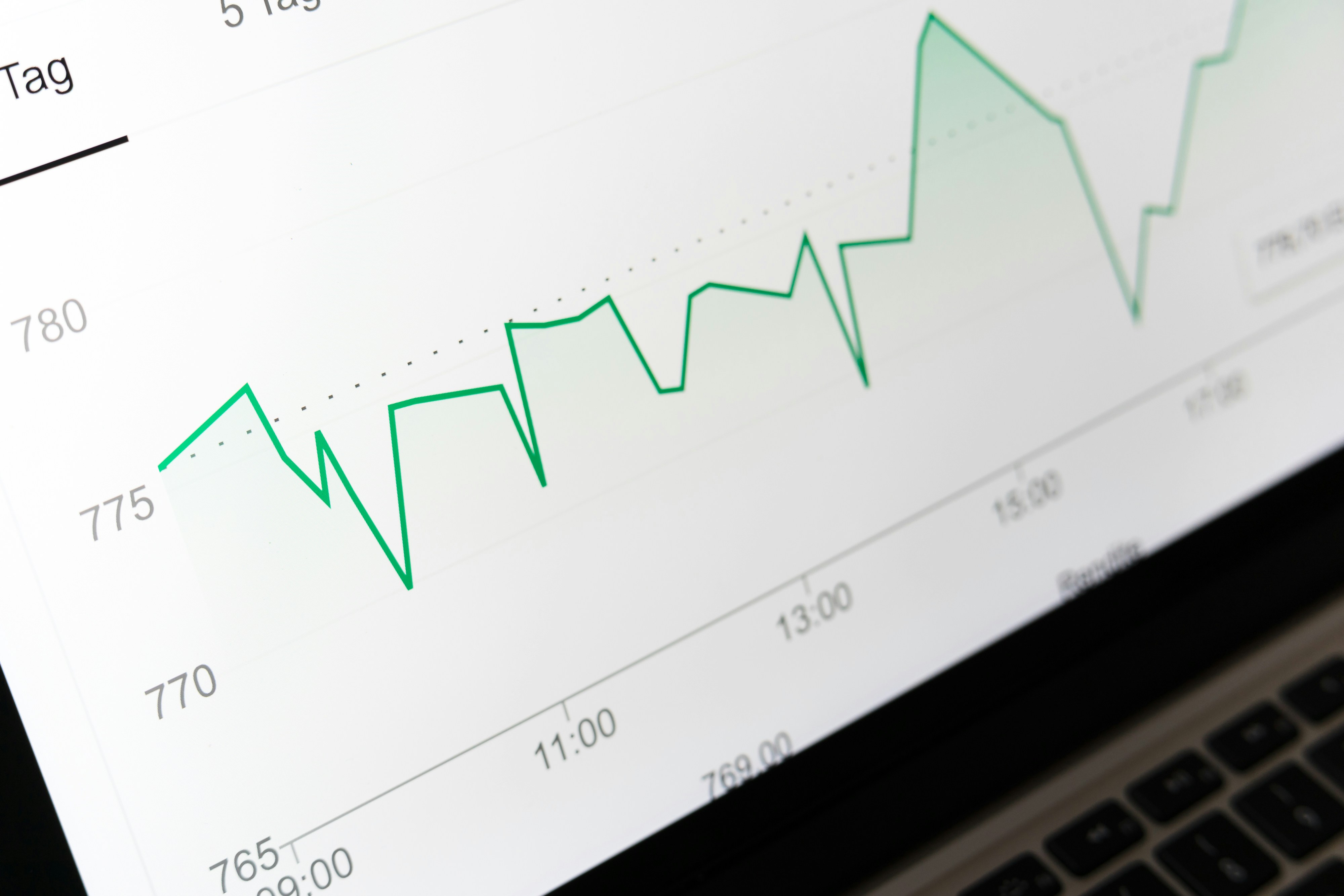 A green upward trend chart on screen — comparing rental yields across properties
