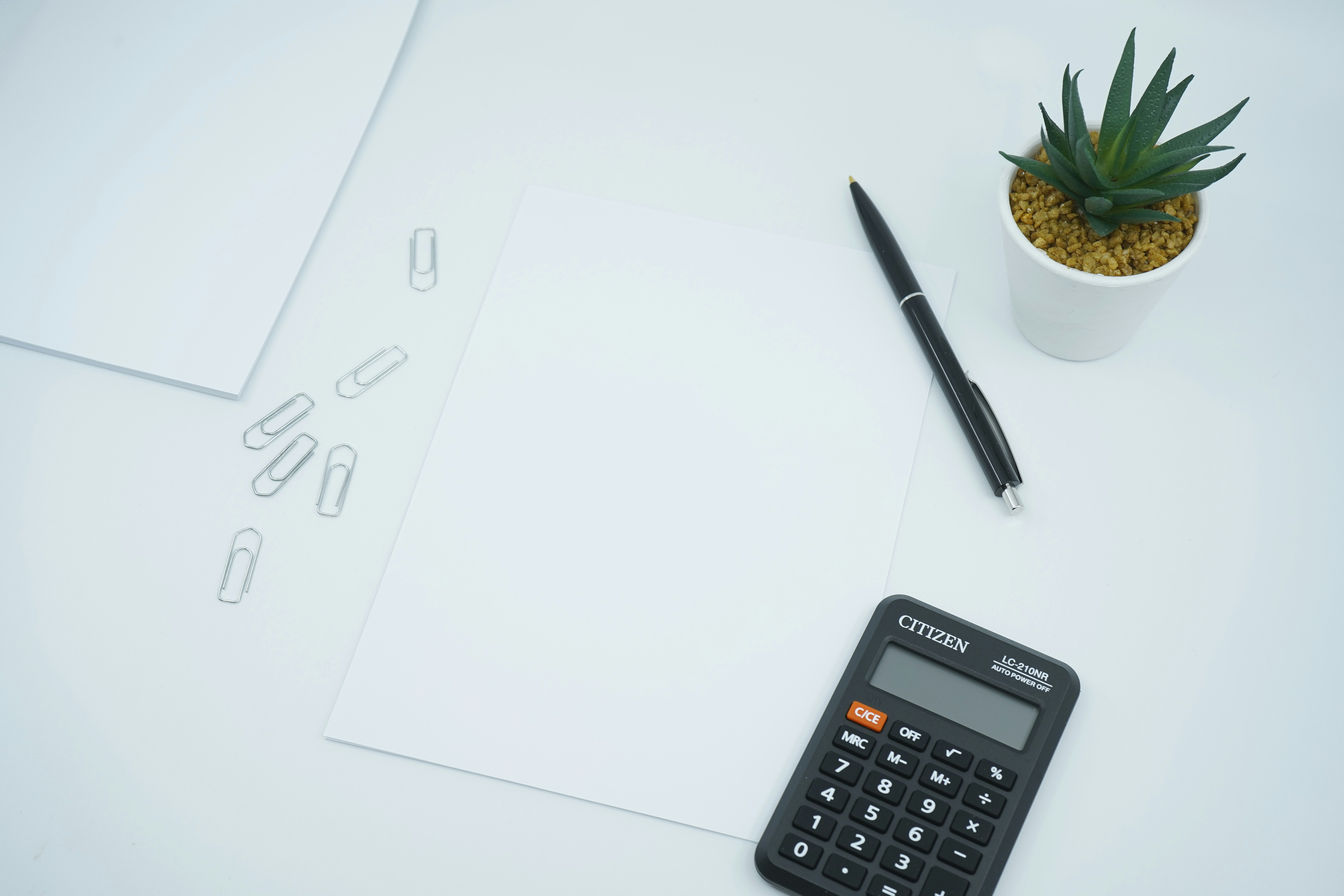 A calculator, pen and paper on a desk — working out gross and net rental yield